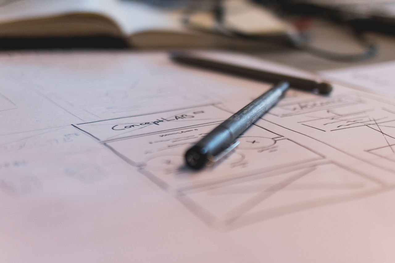 Home A sketch with notes and a pen on paper. Ideal for planning or design concepts.