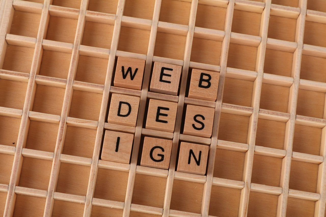 Services Wooden blocks spelling web design on a grid background symbolizing creative digital design concepts.