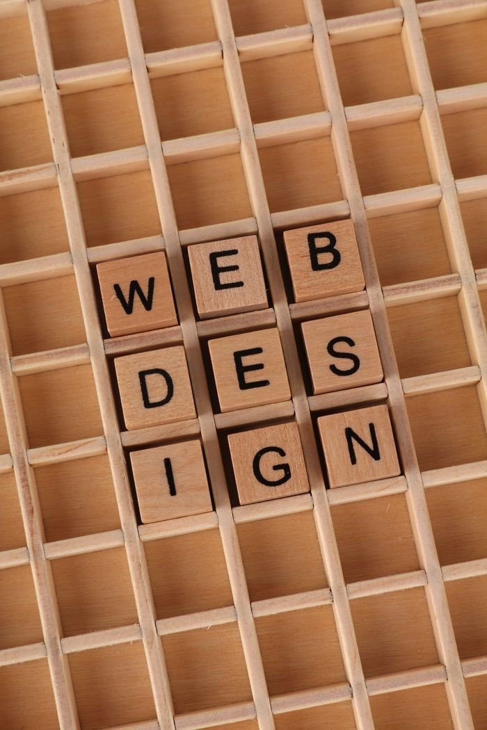 Home Wooden blocks spell 'WEB DESIGN' on a grid, ideal for digital themes.